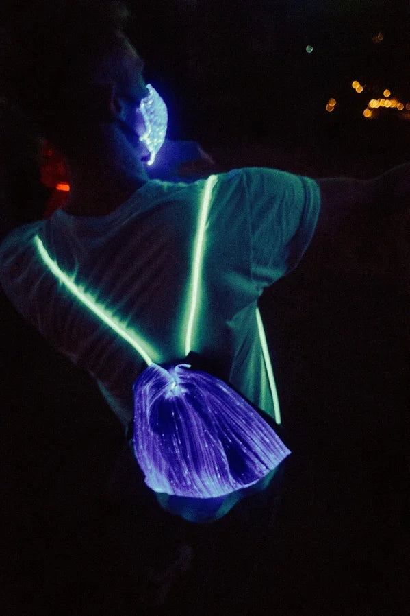 Person mit LED-Maske und leuchtendem LED-Rucksack bei Nacht, Festival-Accessoire