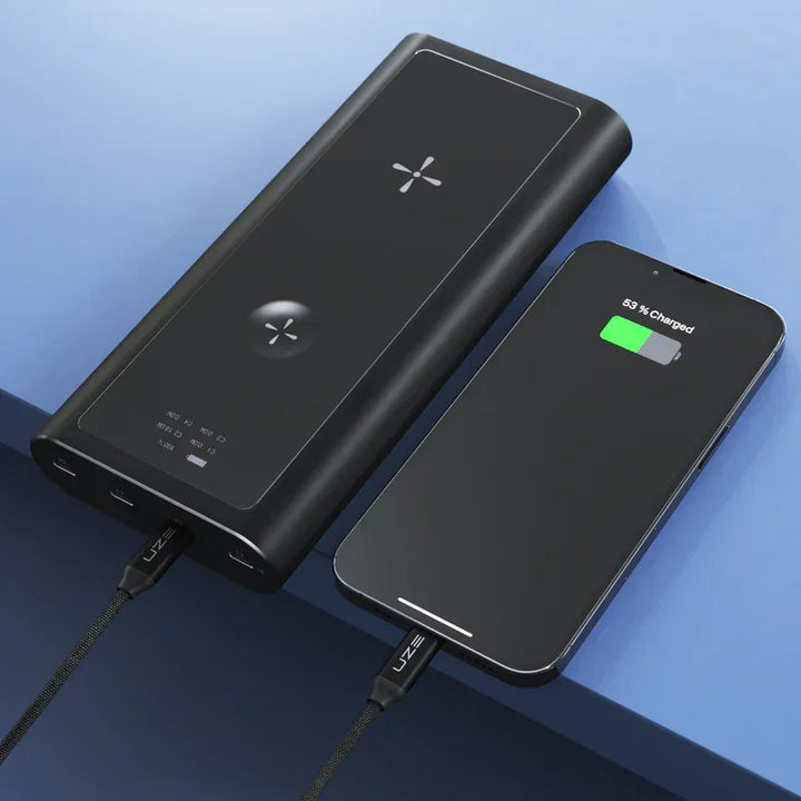 Schwarze Powerbank lädt Smartphone per Kabel, modernes Design auf blauem Hintergrund