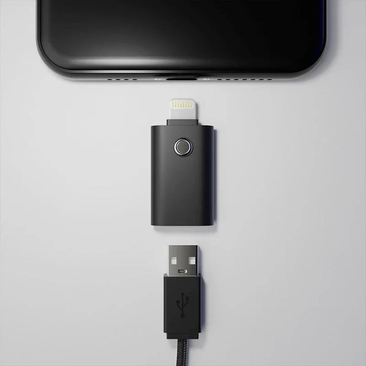 Schwarzer Lightning-zu-USB-Adapter mit Kabel, flach auf weißem Hintergrund angeordnet.
