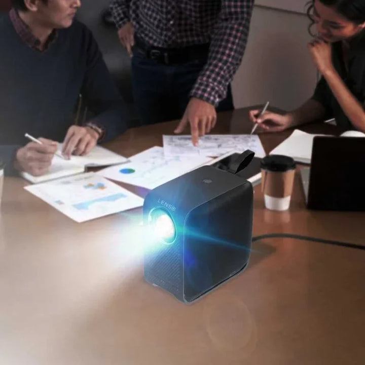 Lenso Solar Beamer projiziert im Büro auf Konferenztisch mit Geschäftspapieren