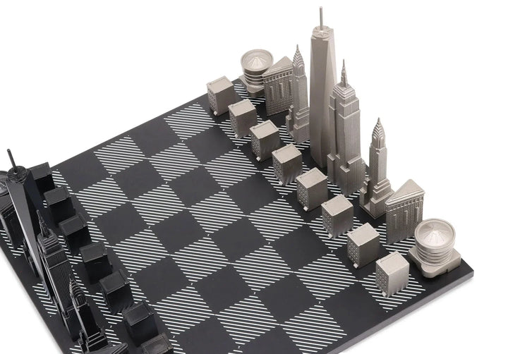 Schachbrett mit New York Skyline Figuren aus Edelstahl auf schwarz-weißem Spielbrett