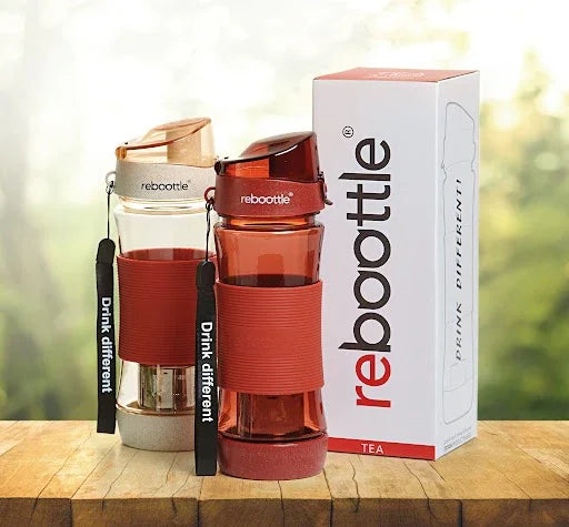 Rebottle Teeflaschen aus Glas mit rotem Silikon, nachhaltige Trinkflaschen auf Holztisch