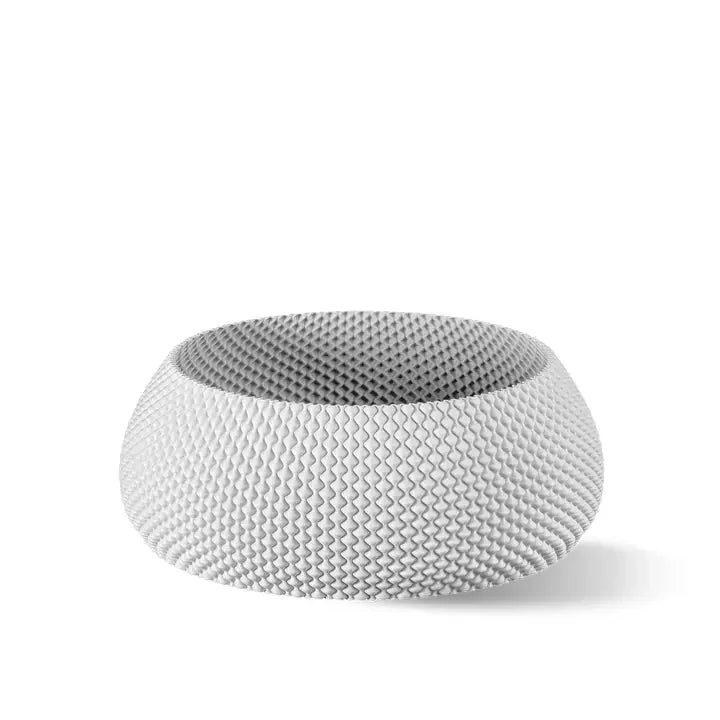 Eine moderne, strukturierte weiße Schüssel mit einem dezenten Wellenmuster, die ein zeitgenössisches Design vor einem schlichten Hintergrund präsentiert.