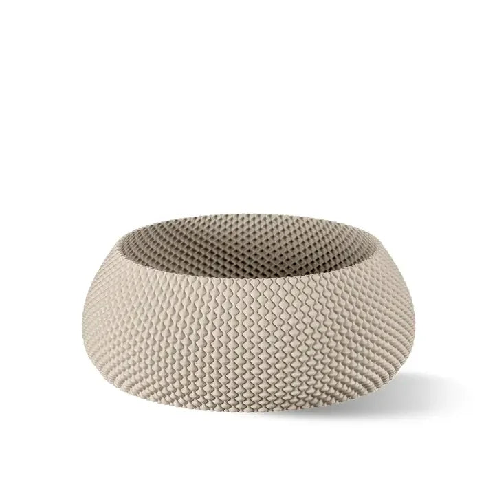 Eine strukturierte, abgerundete Schüssel in einem sanften Beigeton mit Wabenmuster vor weißem Hintergrund.