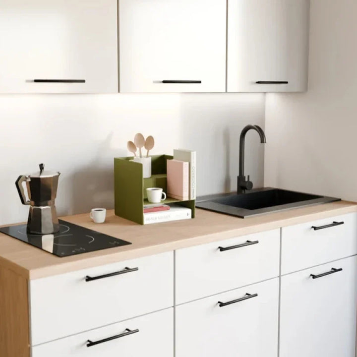 Moderne Küche mit Kaffeezubereiter, grüner Ablage, Büchern und Tassen auf Holzarbeitsplatte