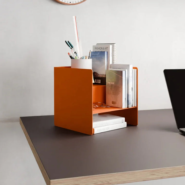 Moderner Schreibtisch mit orangefarbenem Organizer, Büchern und Stiftehalter