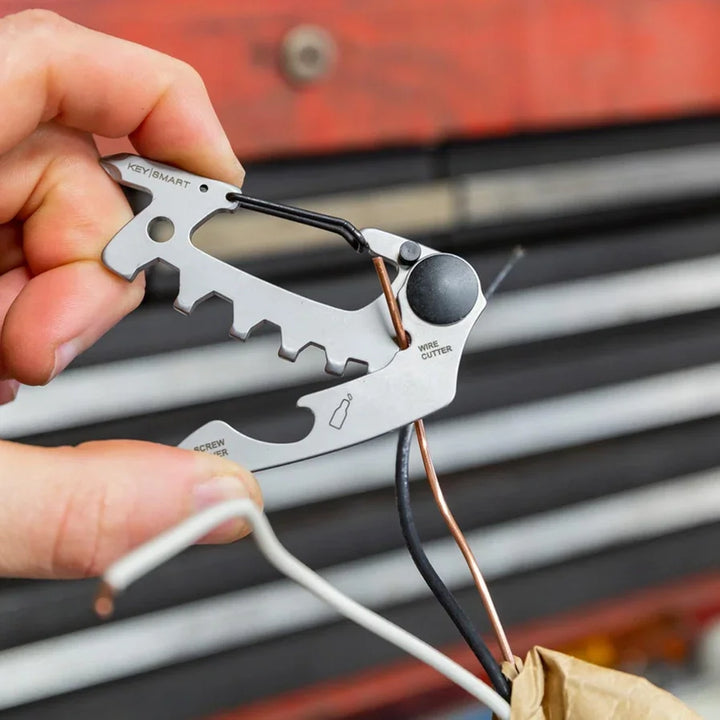 KeySmart AllTul Raptor Multitool schneidet Draht, Nahaufnahme, Hand hält Multitool