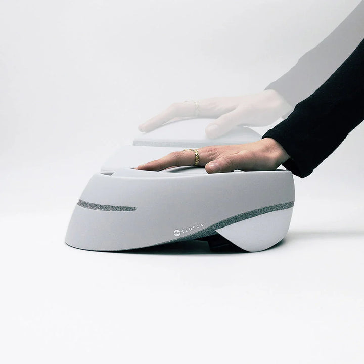 Zusammenklappbarer weißer Fahrradhelm mit Hand, modernes Design, Closca Logo sichtbar