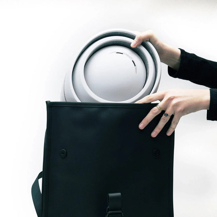 Weiße Fahrradhelm Loop Pearl wird aus schwarzer Tasche gezogen, minimalistisches Design