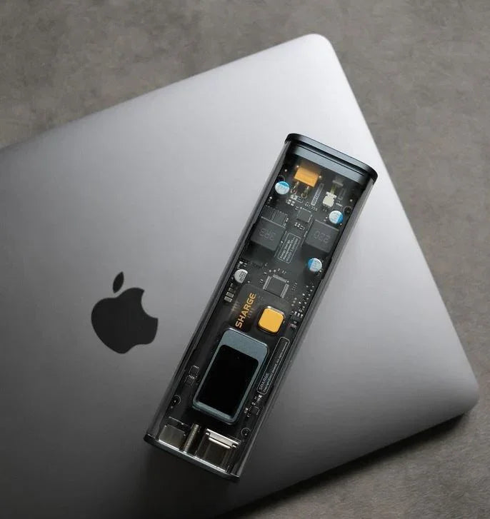 Shargeek 100 Powerbank mit durchsichtigem Gehäuse auf einem geschlossenen MacBook
