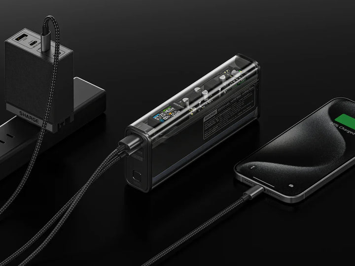 Schwarzes Handy, Ladegerät und Powerbank sind miteinander verbunden.