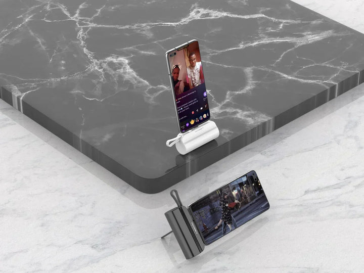 Techancy Mini Charger lädt zwei Smartphones, auf weißem Marmortisch platziert